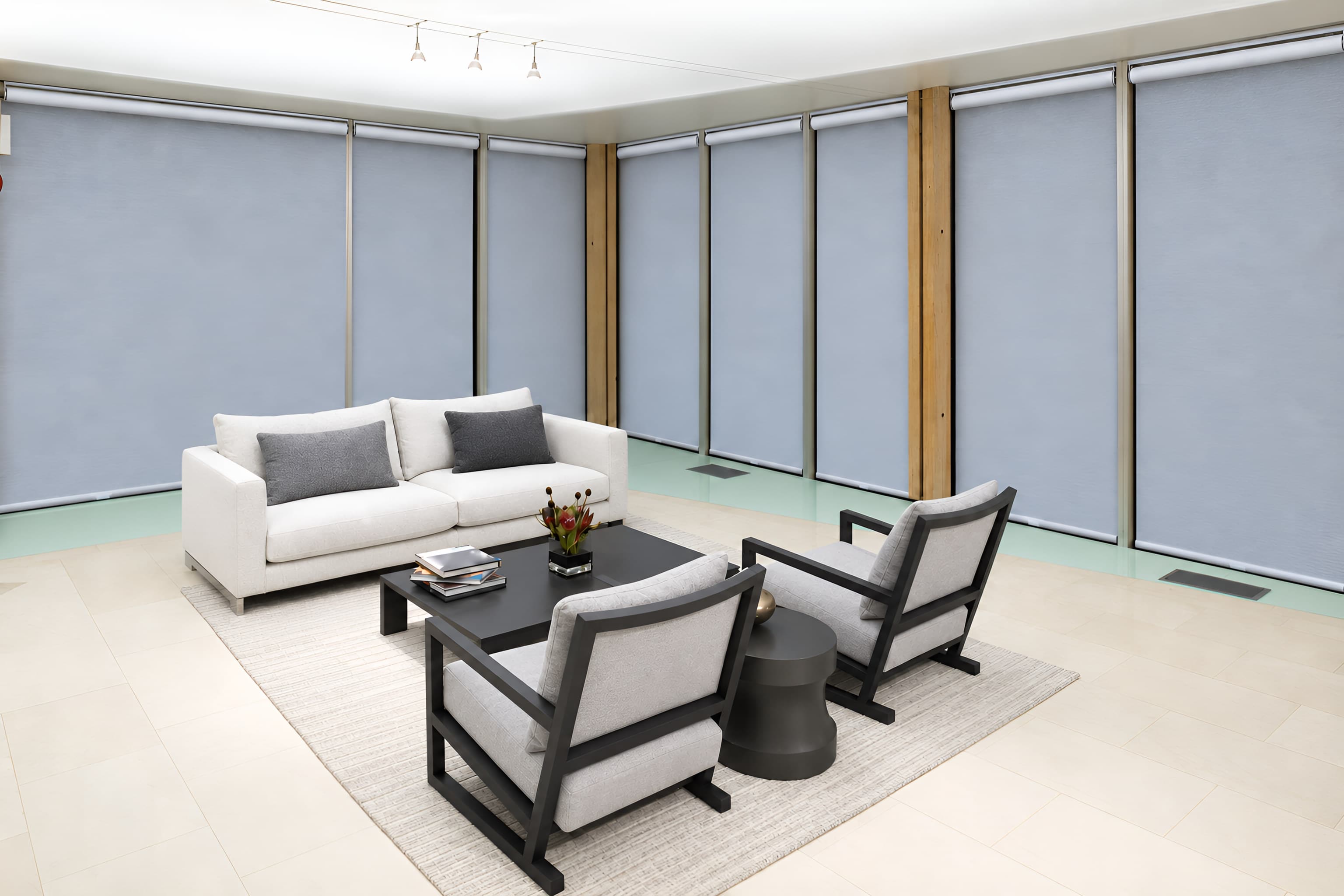 Roller shades lowered across a full wall of windows in a lounge